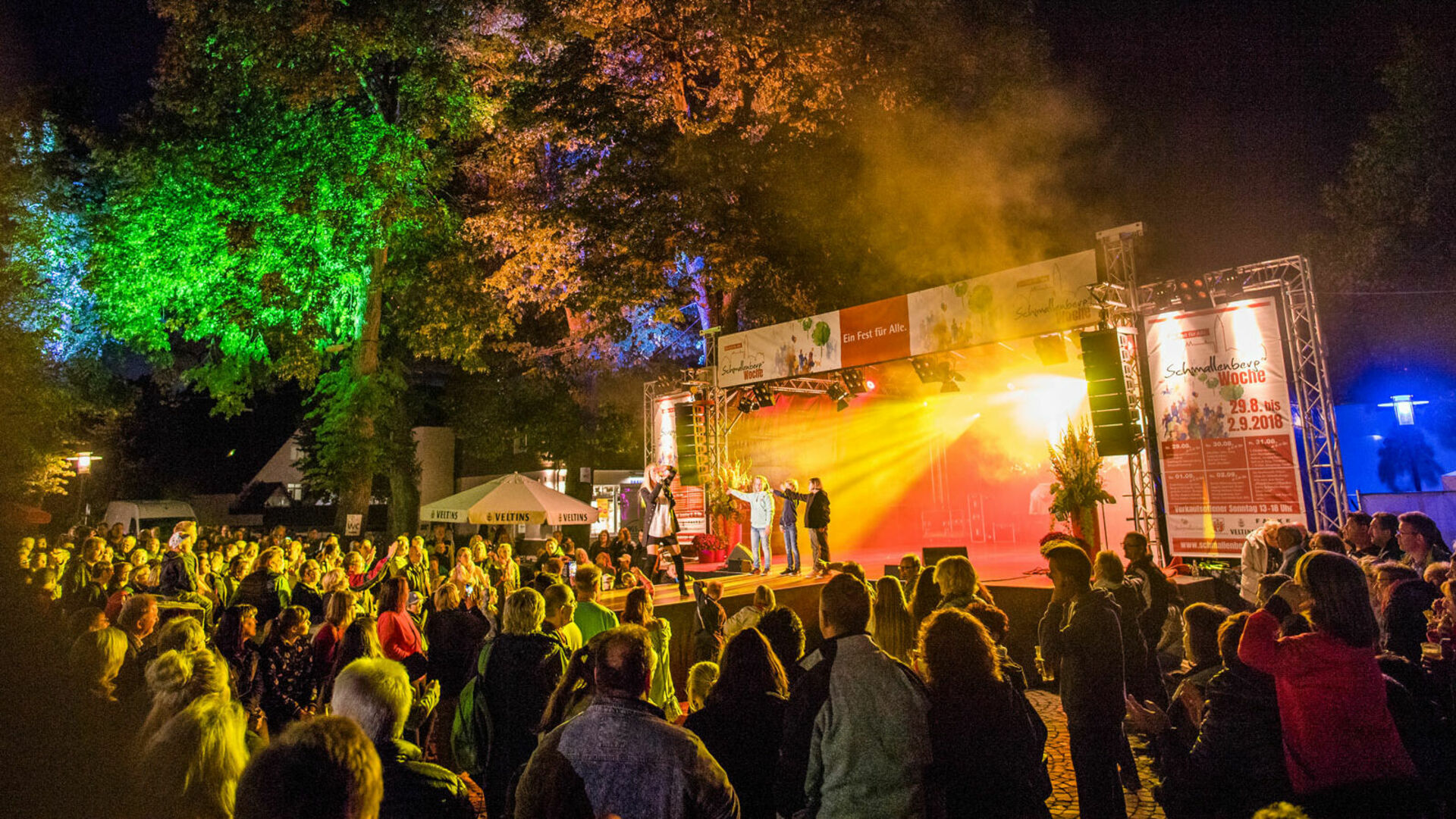 Veranstaltung bei Nacht, Bühne beleuchtet, Puplikum 